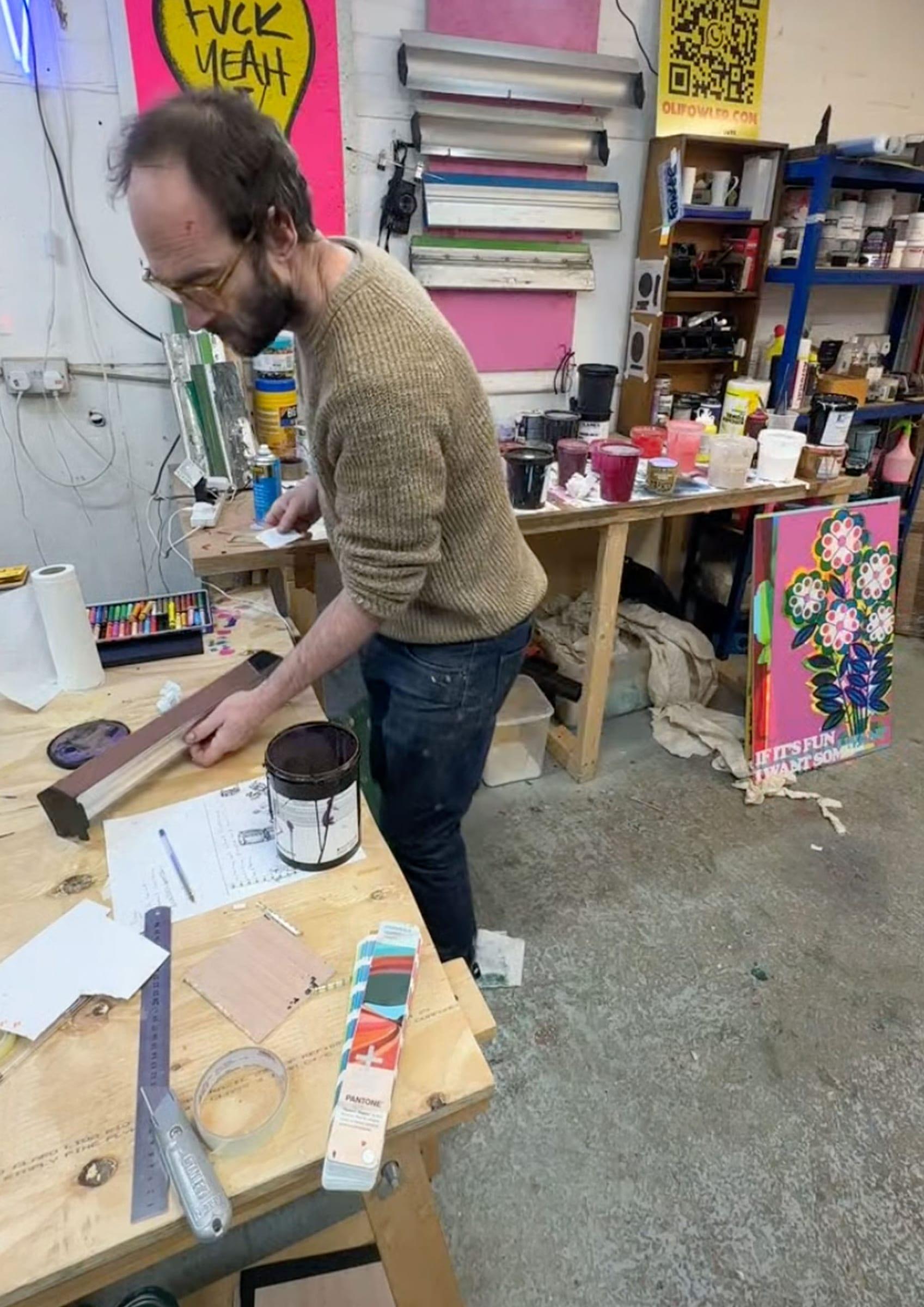Studio workbench with a Pantone swatch book, squeegee and ink tin